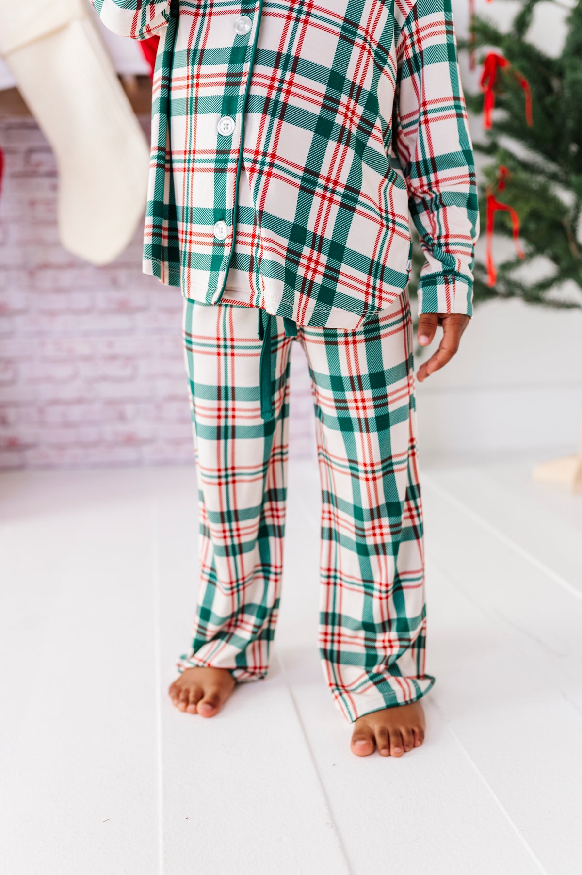 A close-up shot of bamboo pajamas in a classic Christmas plaid print in red, green, and cream 