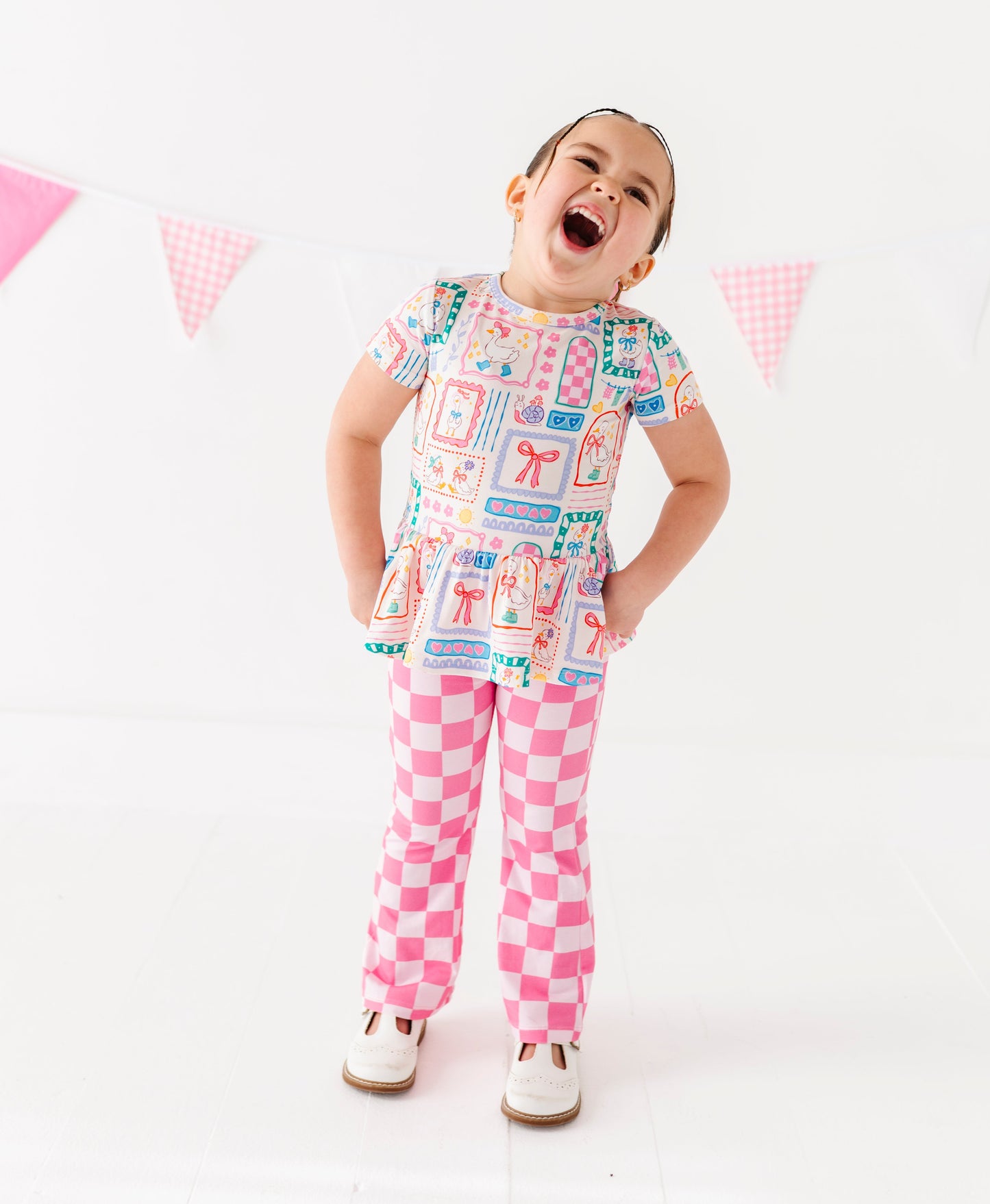 Child wearing a colorful bamboo/cotton blend outfit with a checkered pattern on a white background