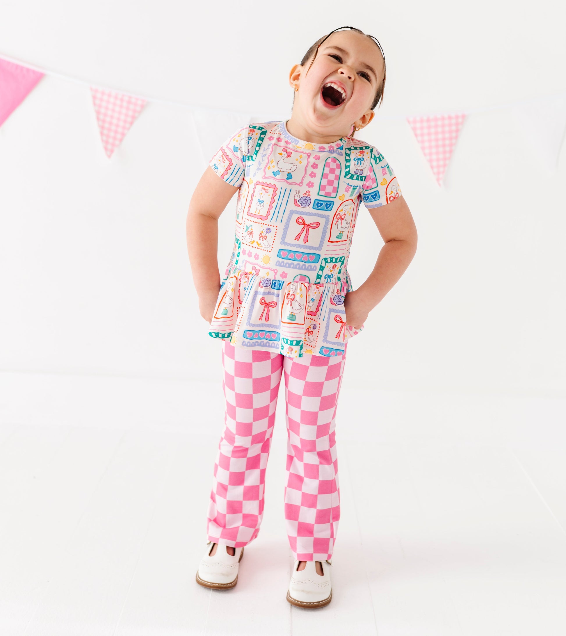 Child wearing a colorful bamboo-cotton blend outfit with a checkered pattern on a white background