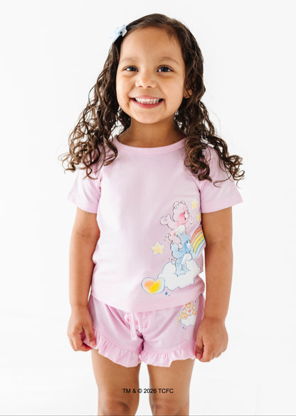 Young girl wearing a lilac outfit with Care Bears™ design on a white background