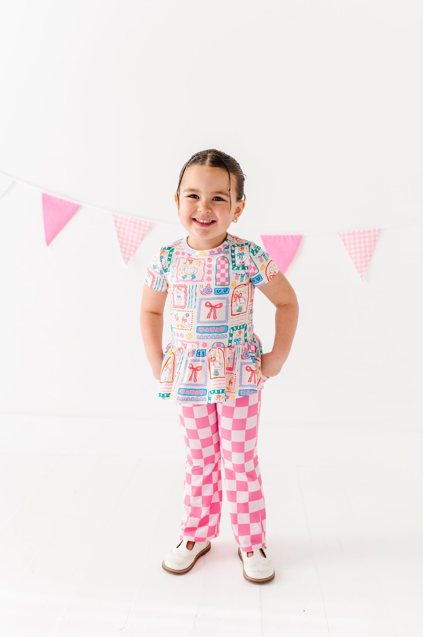 Child wearing a colorful bamboo outfit with a checkered pattern on a white background