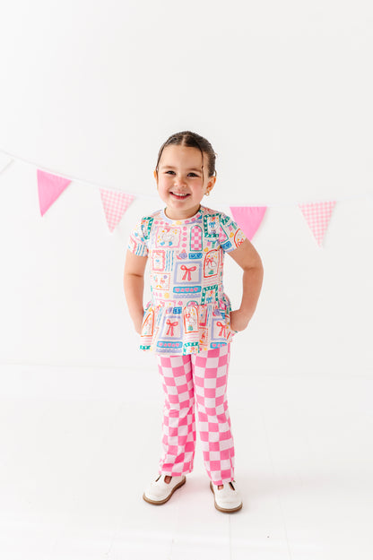 Child wearing a colorful bamboo outfit with a checkered pattern on a white background