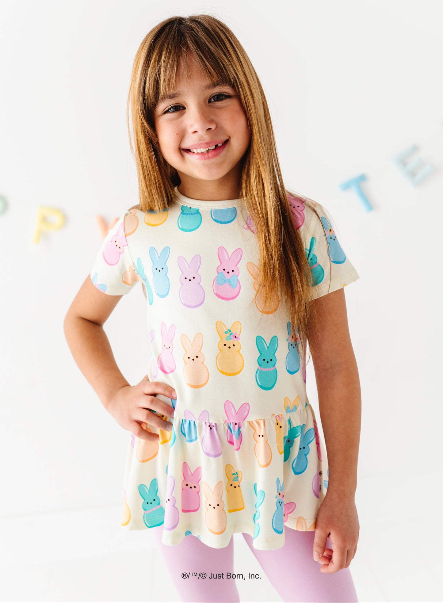 Young girl wearing a top with colorful  PEEPS® bunny print on a white background
