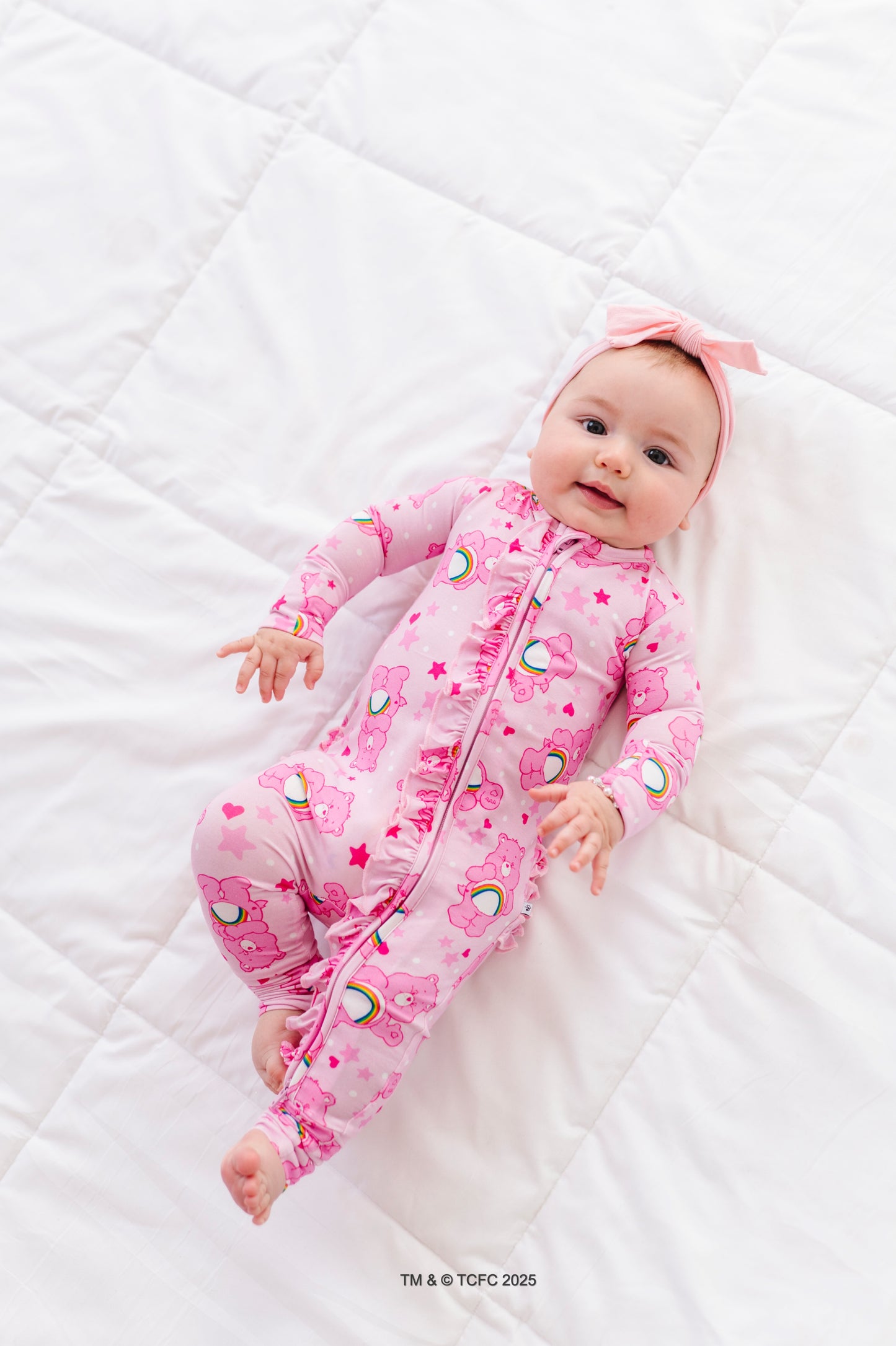 Pink Care Bears Cheer Bear baby romper with rainbow print and ruffle details