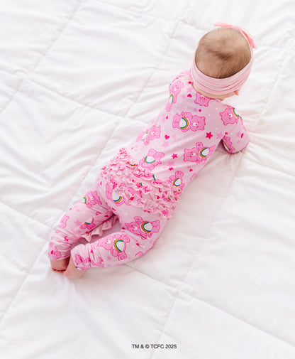 Infant in Care Bears Cheer Bear bamboo romper with ruffles on the back