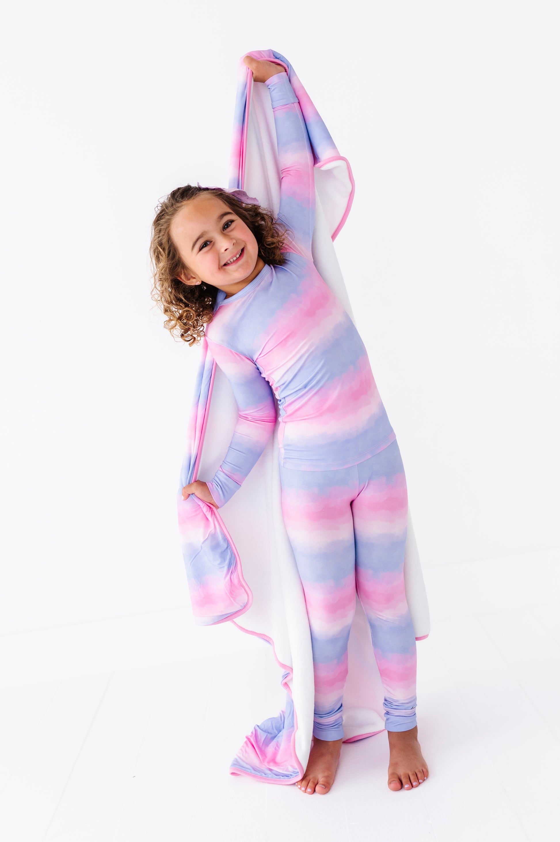 Child wearing a colorful bamboo pj set on a white background