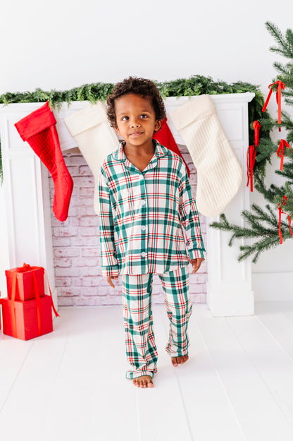 A litlte boy wearing classic plaid pajamas for a Christmas theme 