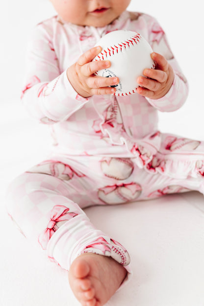 Baby holding a baseball wearing a pink and white bamboo convertible romper  