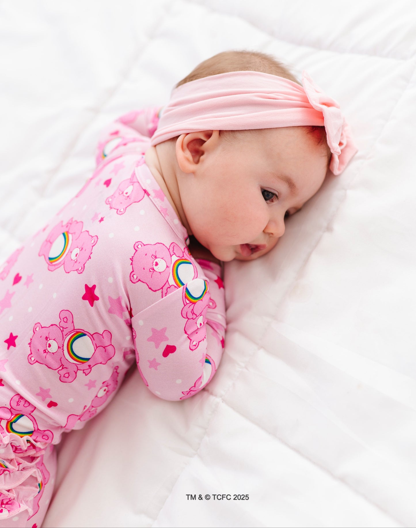 Baby wearing pink Care Bears Cheer Bear sleeper made from breathable bamboo