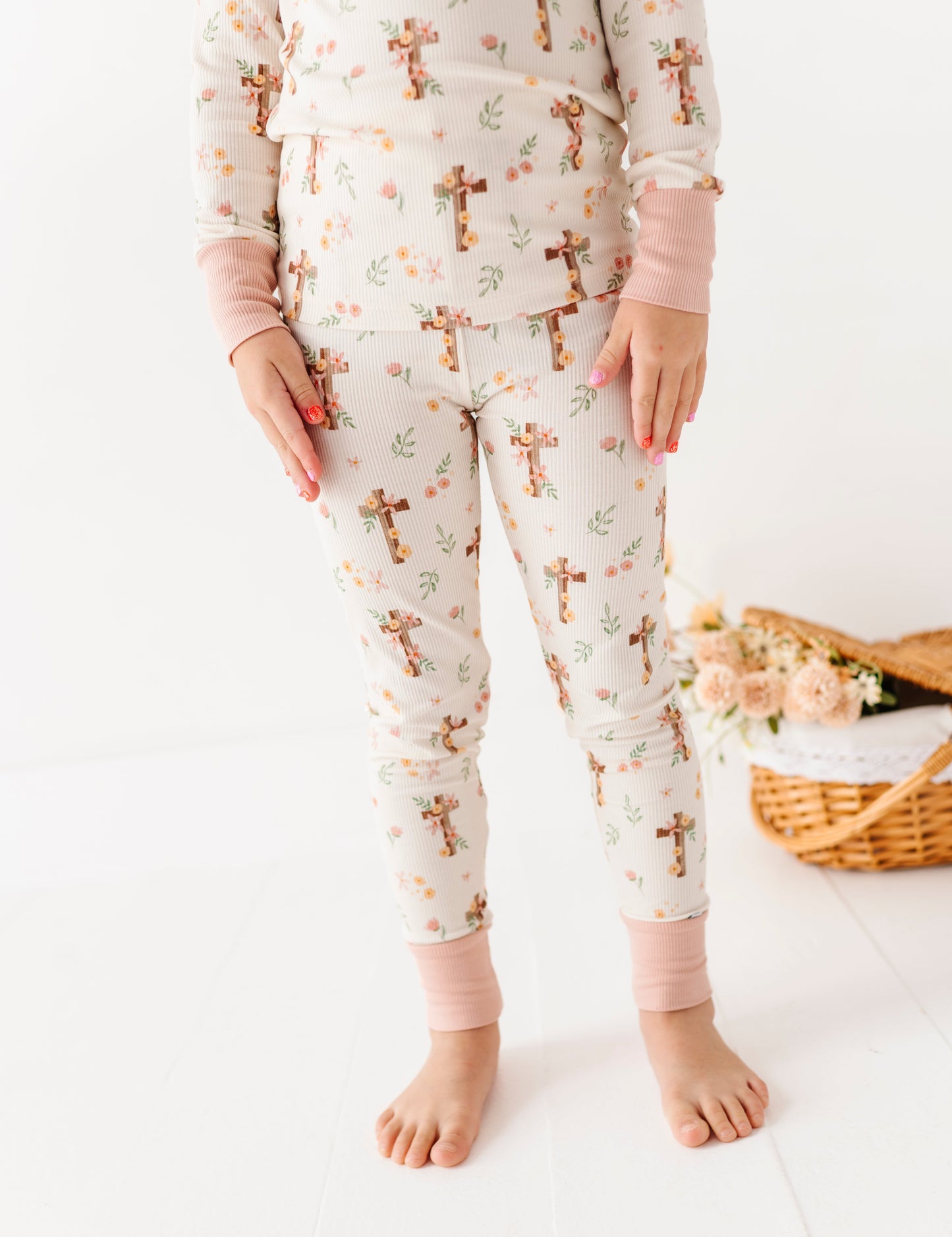 Child wearing Easter pajamas with cross patterns on a white background