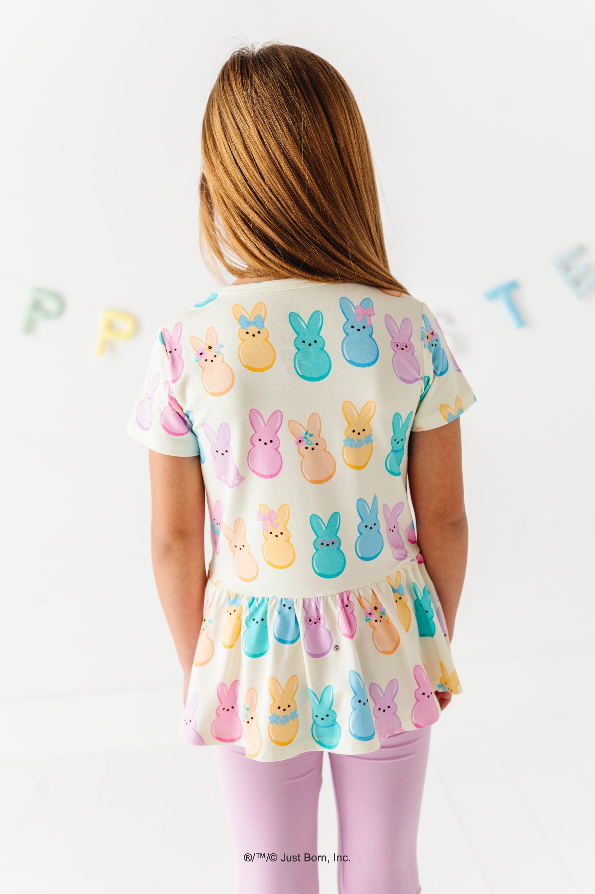 Child wearing a top with Peeps character print on a white background