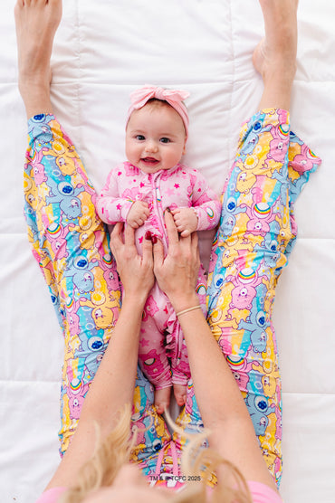 Mom wearing Care Bears Stare bamboo pajama set holding baby in matching Care Bears outfit