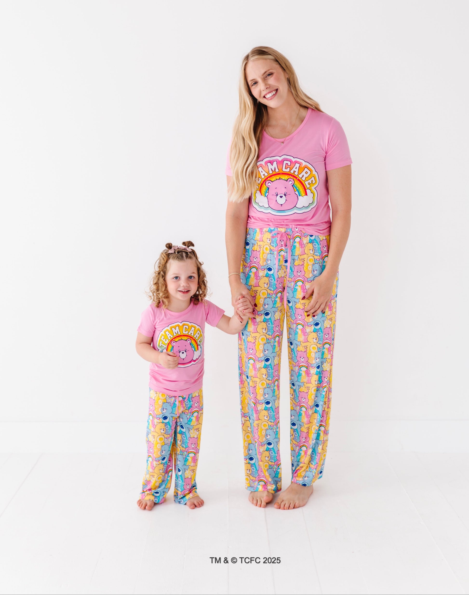 Matching mom and toddler wearing Care Bears bamboo pajama sets on white background