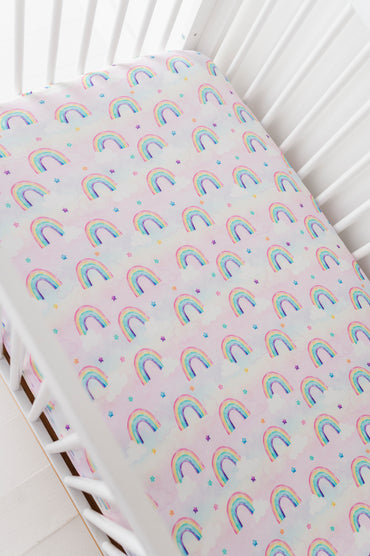 Fitted bamboo crib sheet with rainbow watercolor pattern on a crib