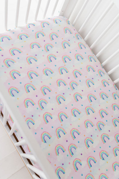Fitted bamboo crib sheet with rainbow watercolor pattern on a crib
