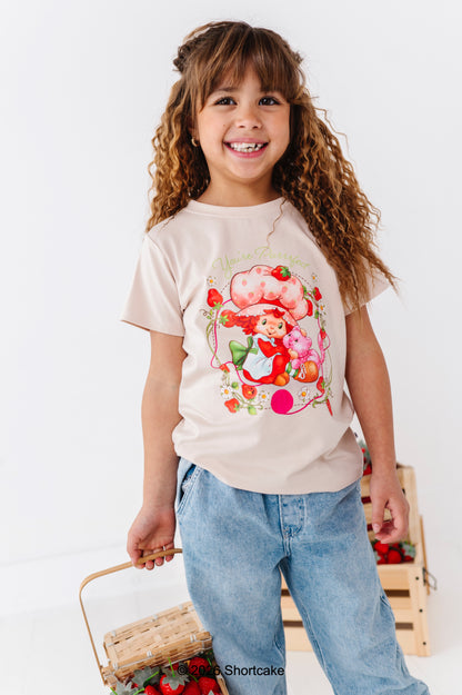 Child wearing a Strawberry Shortcake™ t-shirt and light-wash denim jeans on a white background