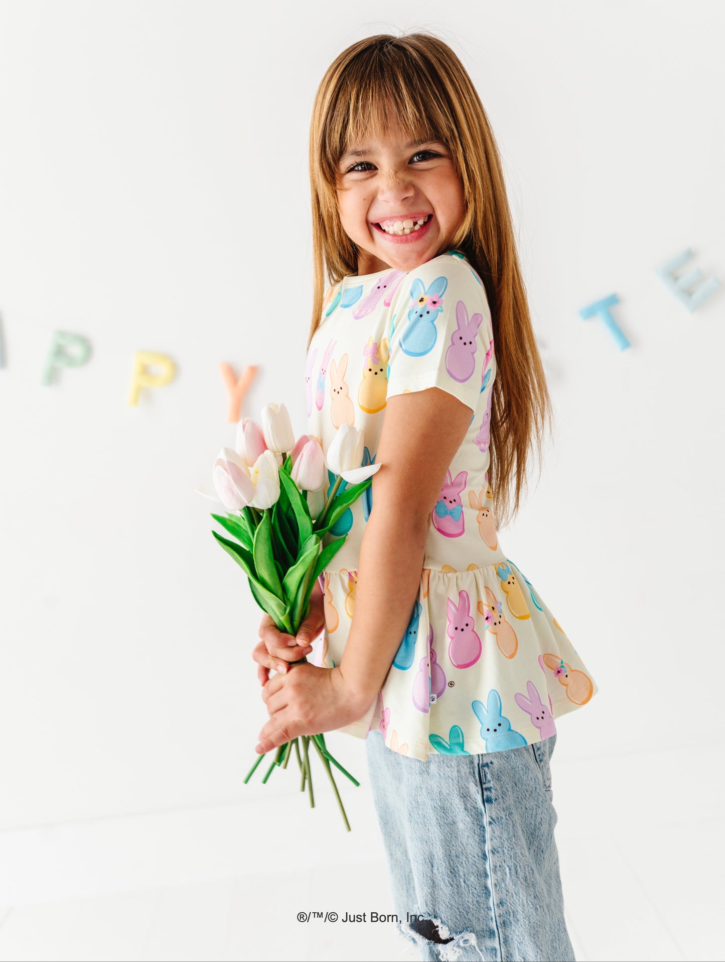 Young girl holding a bouquet of flowers, wearing a colorful PEEPS® shirt 