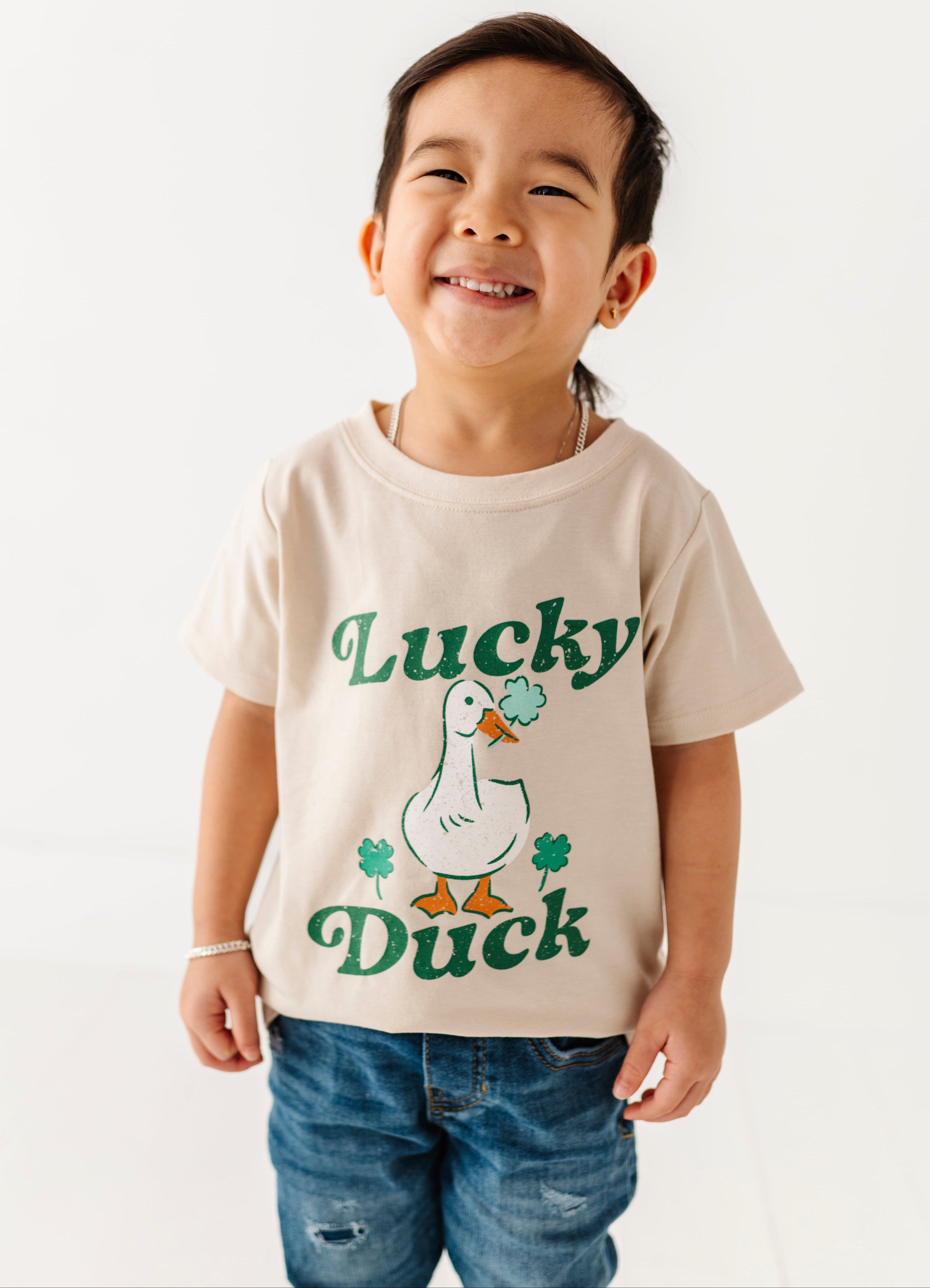 Child wearing a 'Lucky Duck' t-shirt on a white background
