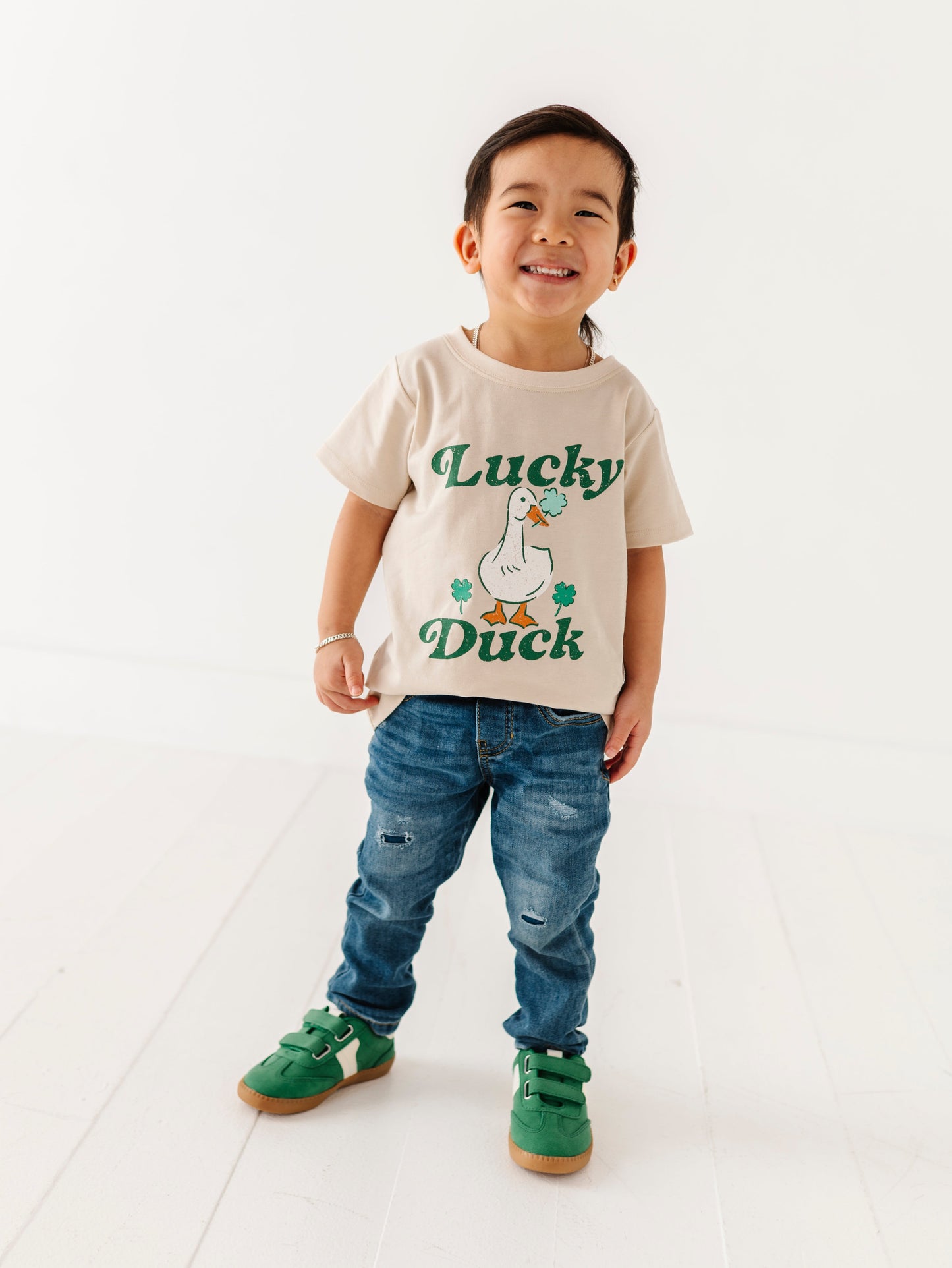 Child wearing a 'Lucky Duck' t-shirt on a white background