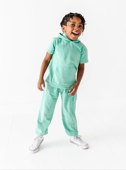 Child wearing a light green outfit on a white background