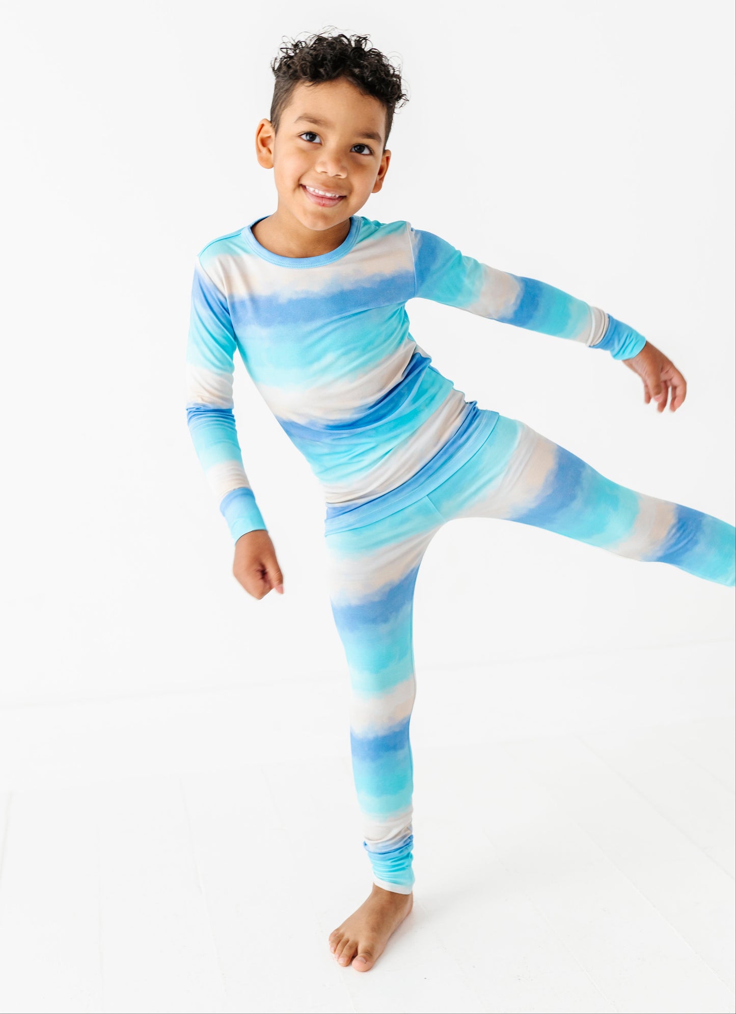 Child wearing a blue and white striped bamboo pajama set on a white background