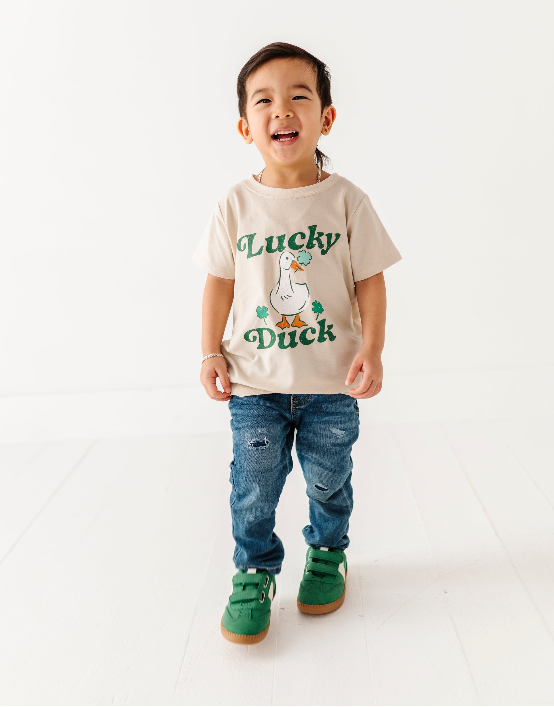 Child wearing a 'Lucky Duck' t-shirt on a white background