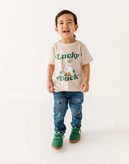 Child wearing a 'Lucky Duck' t-shirt on a white background