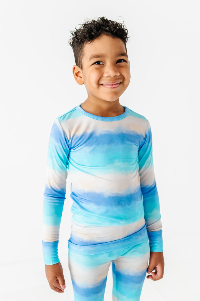 Child wearing a blue and white ombre long-sleeve bamboo shirt and pants on a white background
