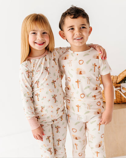 Two children wearing ribbed bamboo pajamas with cross patterns standing close together.