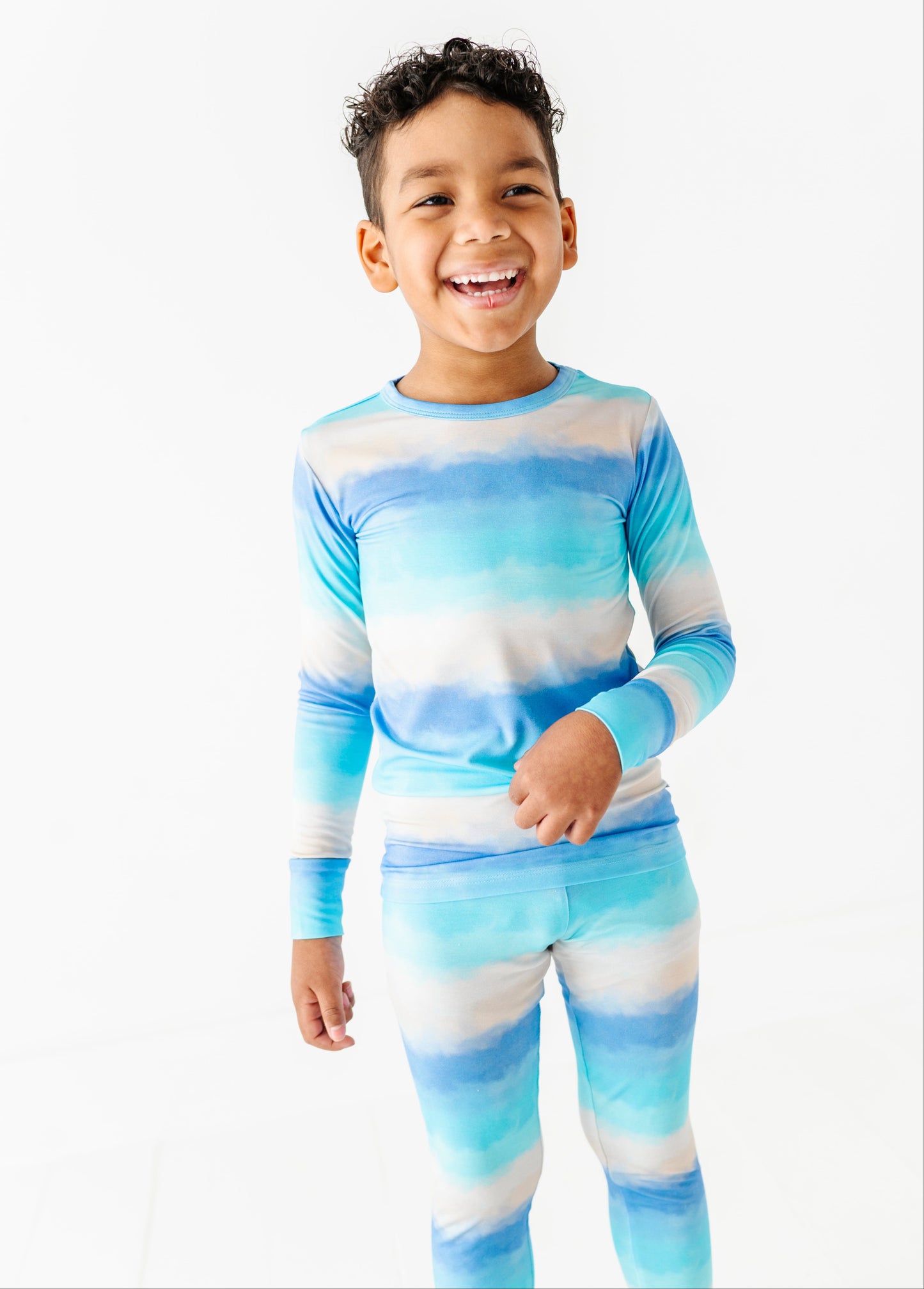 Child wearing a blue and white striped bamboo pajama set on a white background