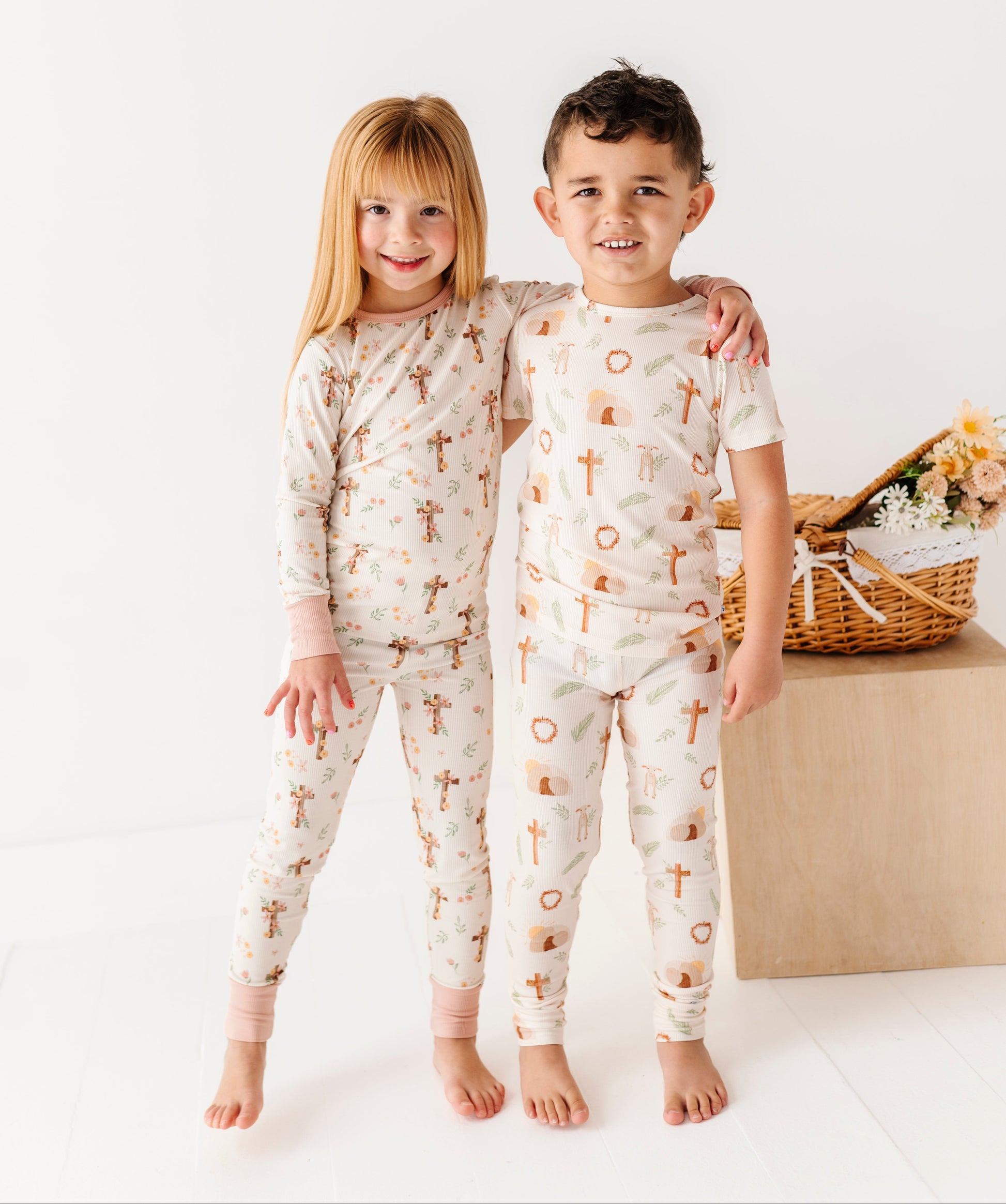 Two children wearing pajamas with a cross pattern on a white background