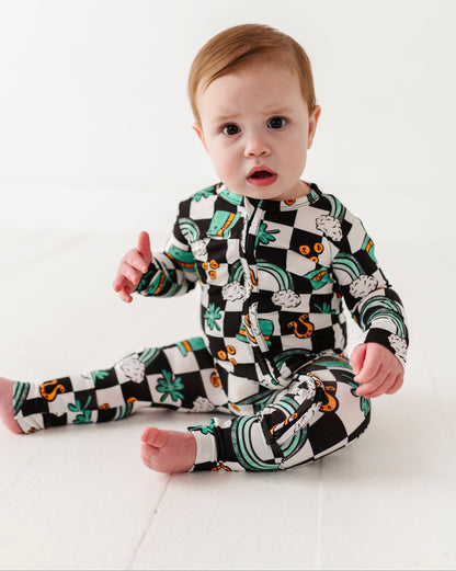 Baby wearing a black and white checkered St. Patrick's Day convertible romper on a white background