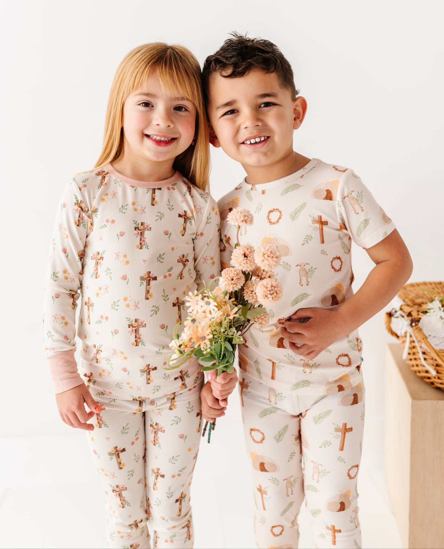 Two children wearing pajamas with a cross pattern on a white background