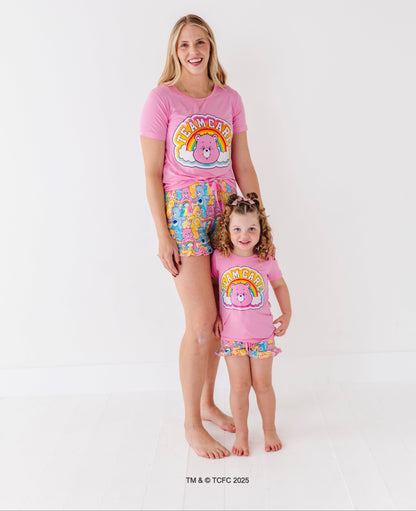 Woman and child wearing matching Care Bears™ Stare pajama sets, smiling