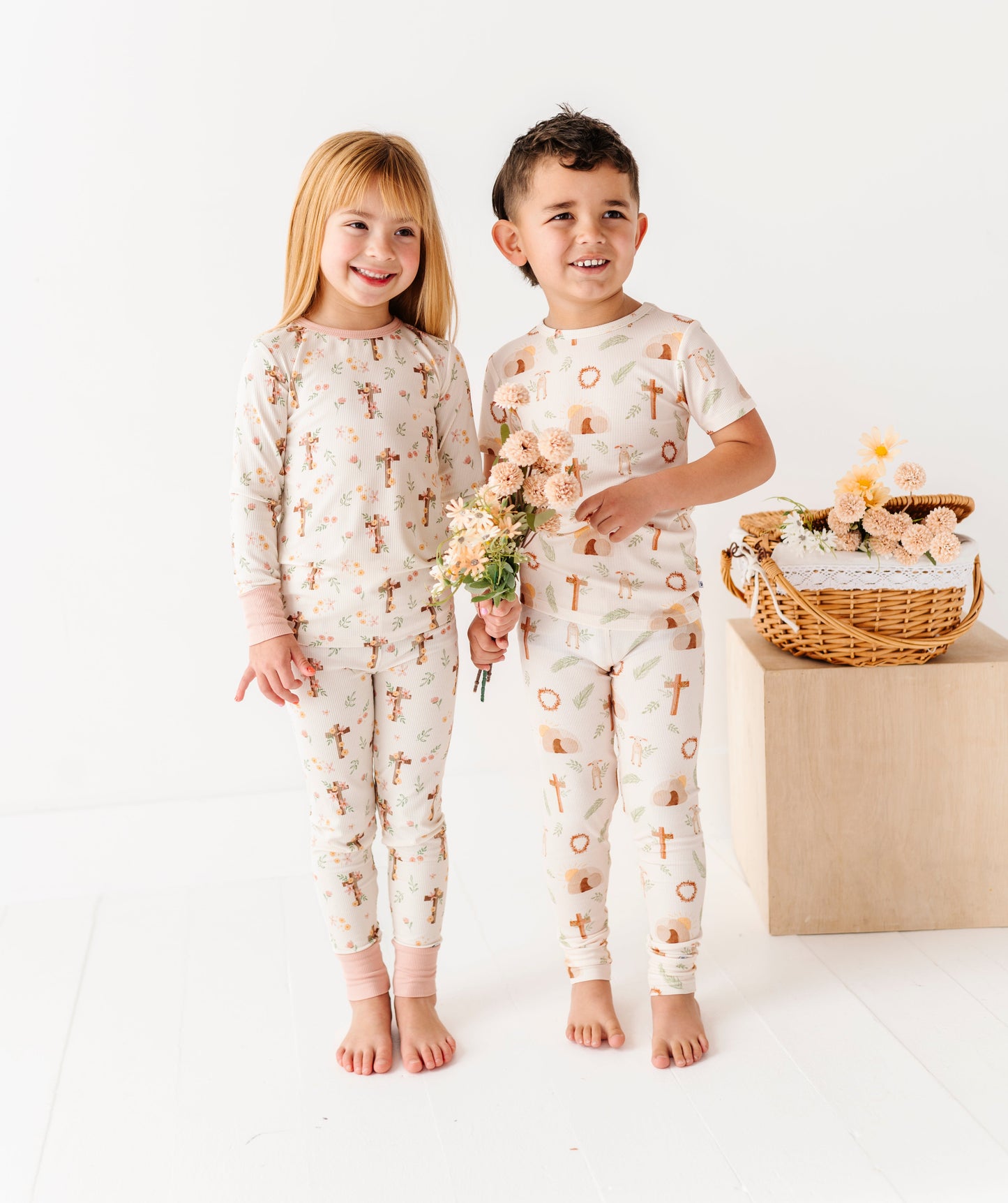 Two children wearing matching Easter pajamas with a floral pattern on a white background.