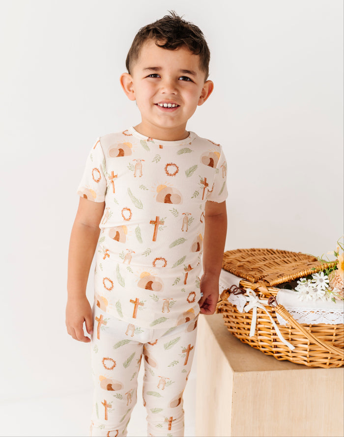 Boy wearing religious bamboo Easter pajamas with crosses on them .