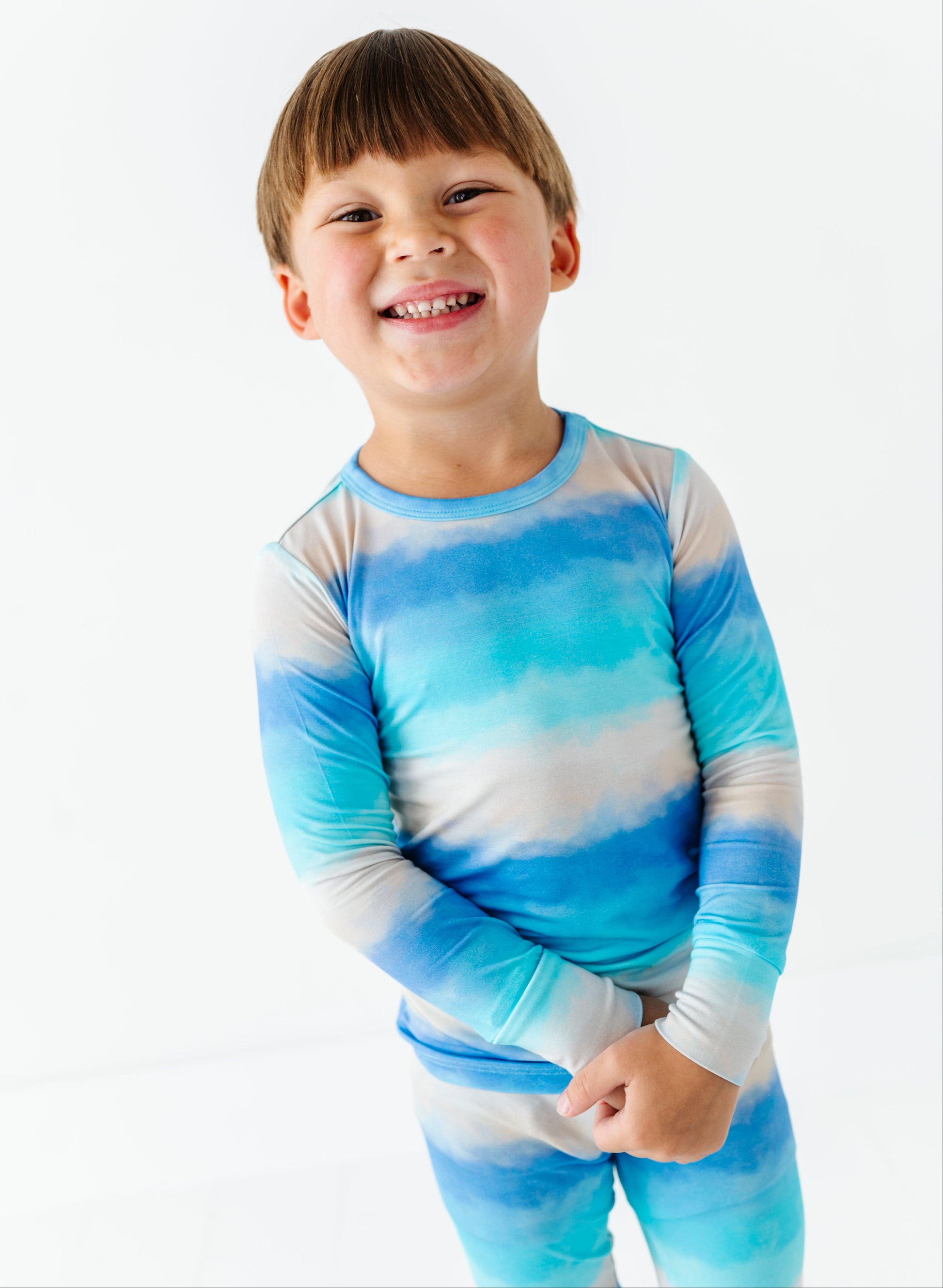 Child wearing a blue and white tie-dye bamboo pajama set on a white background