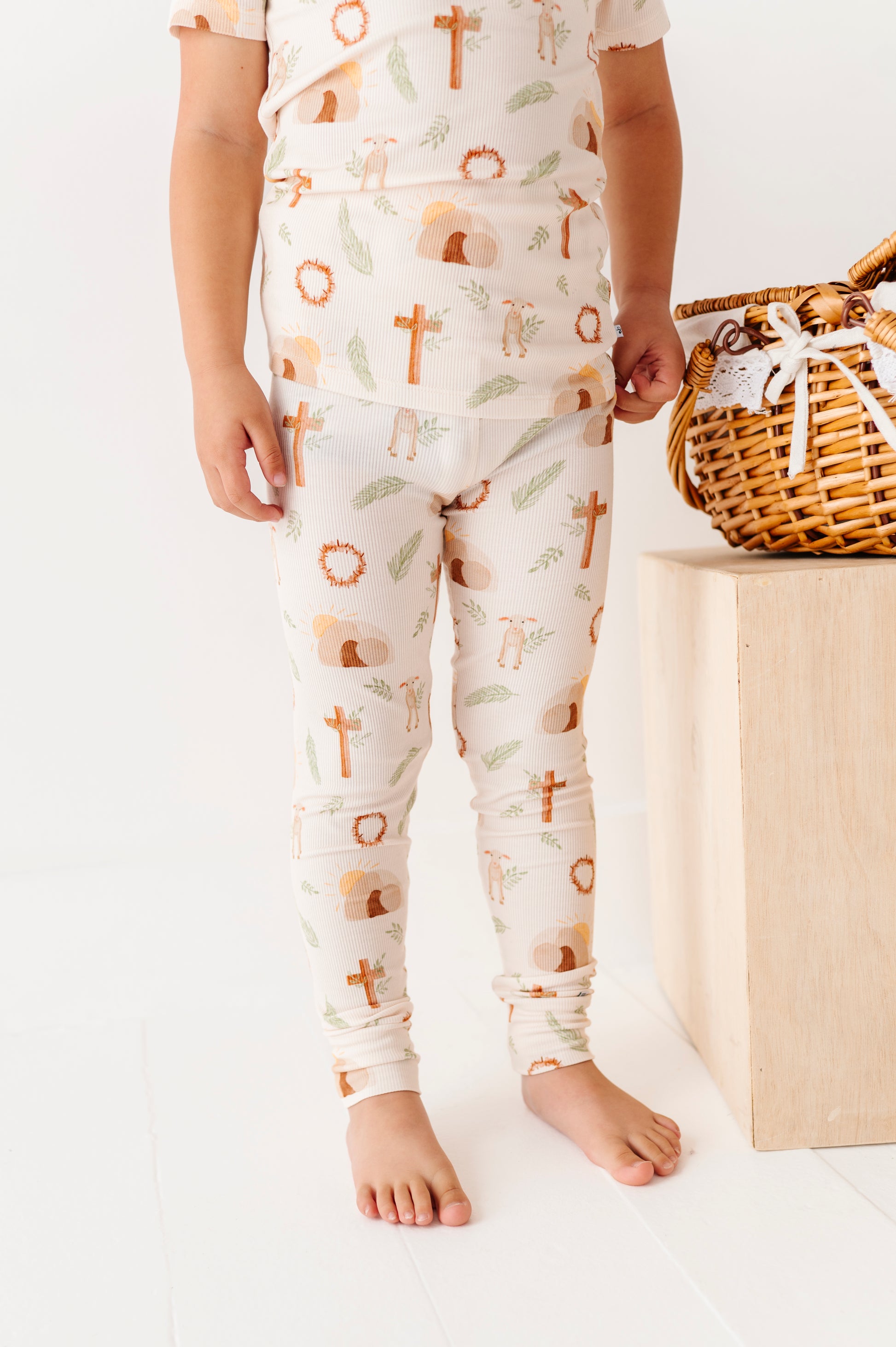 Child wearing pajamas with cross patterns on a white background