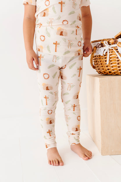 Child wearing pajamas with cross patterns on a white background