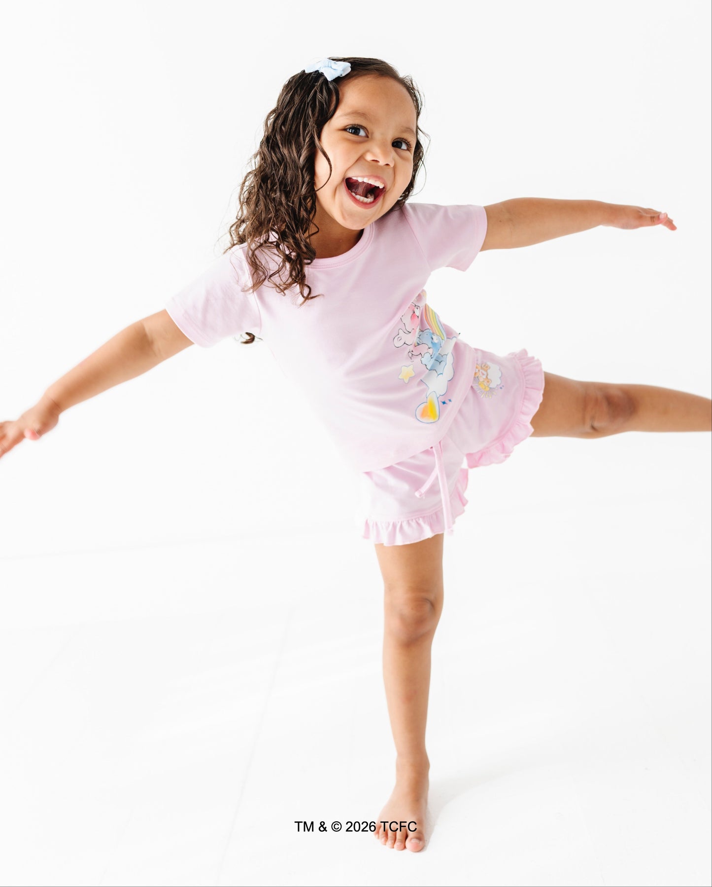 Child in a lilac outfit with Care Bears™ on a white background