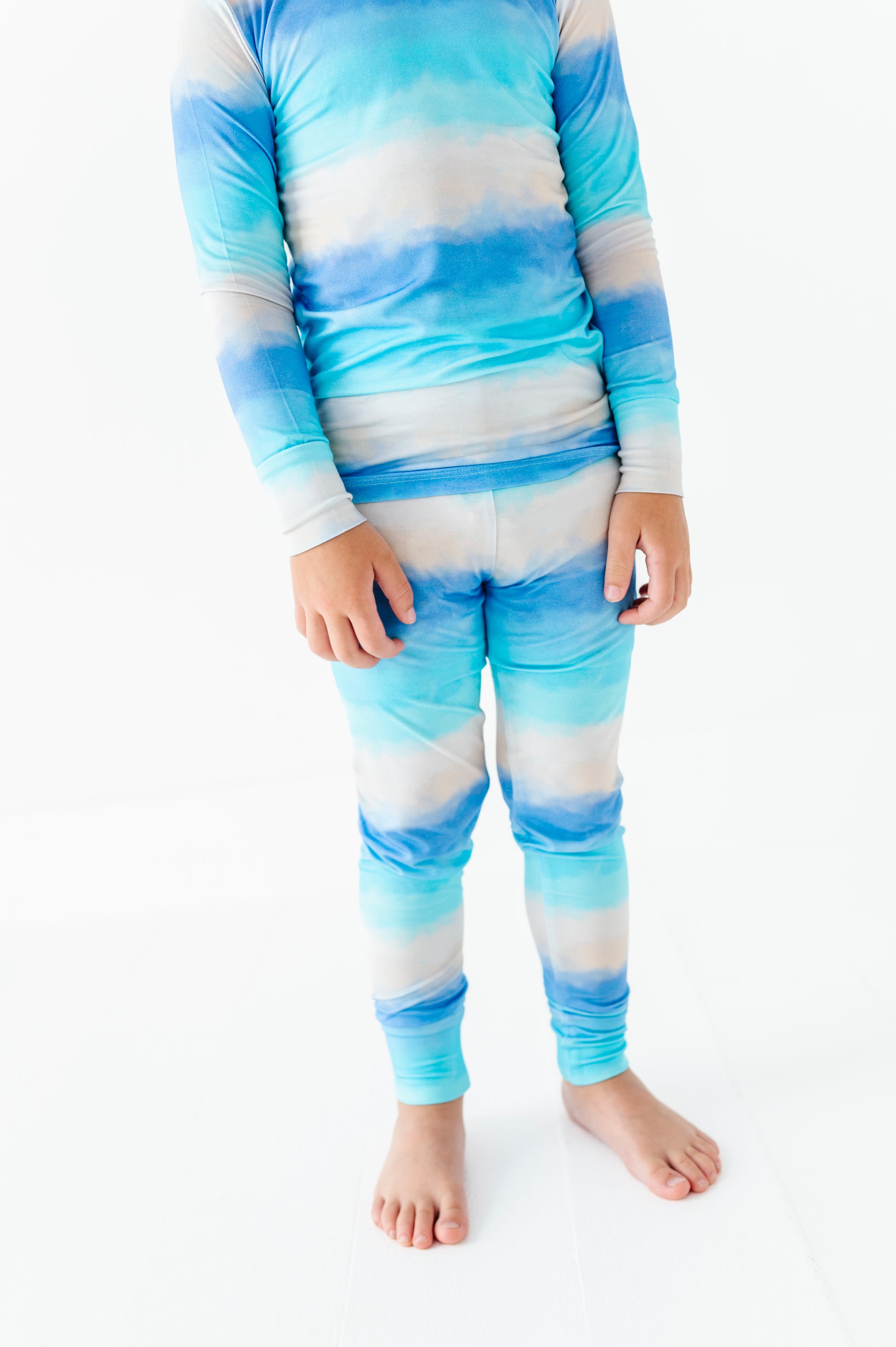 Child wearing a blue and white striped bamboo pj set on a white background
