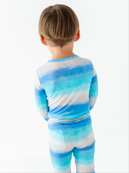 Child wearing a blue and white tie-dye bamboo pj set on a white background