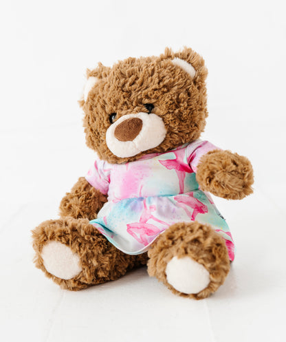 Plush teddy bear wearing a watercolor bamboo outfit on a white background