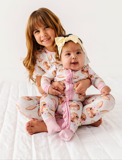 Two children wearing matching bamboo pajamas with animal print on a white background
