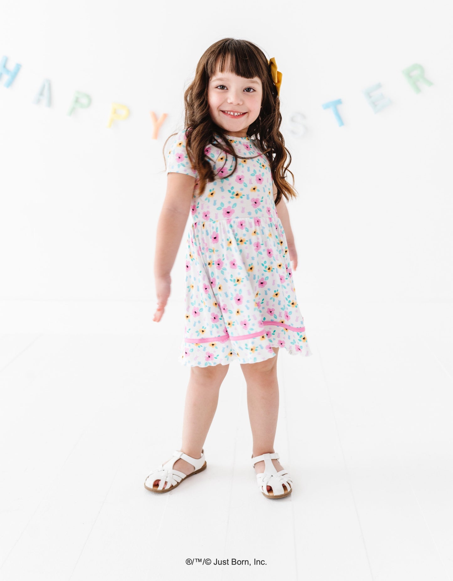 Young girl wearing a floral PEEPS® dress standing against a white background with 'Happy Easter' banner.