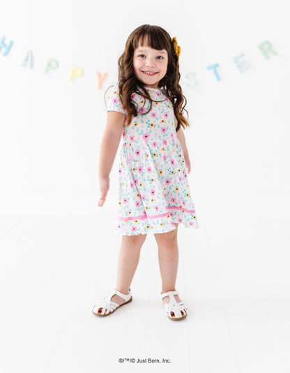 Young girl wearing a floral PEEPS® dress standing against a white background with 'Happy Easter' banner.