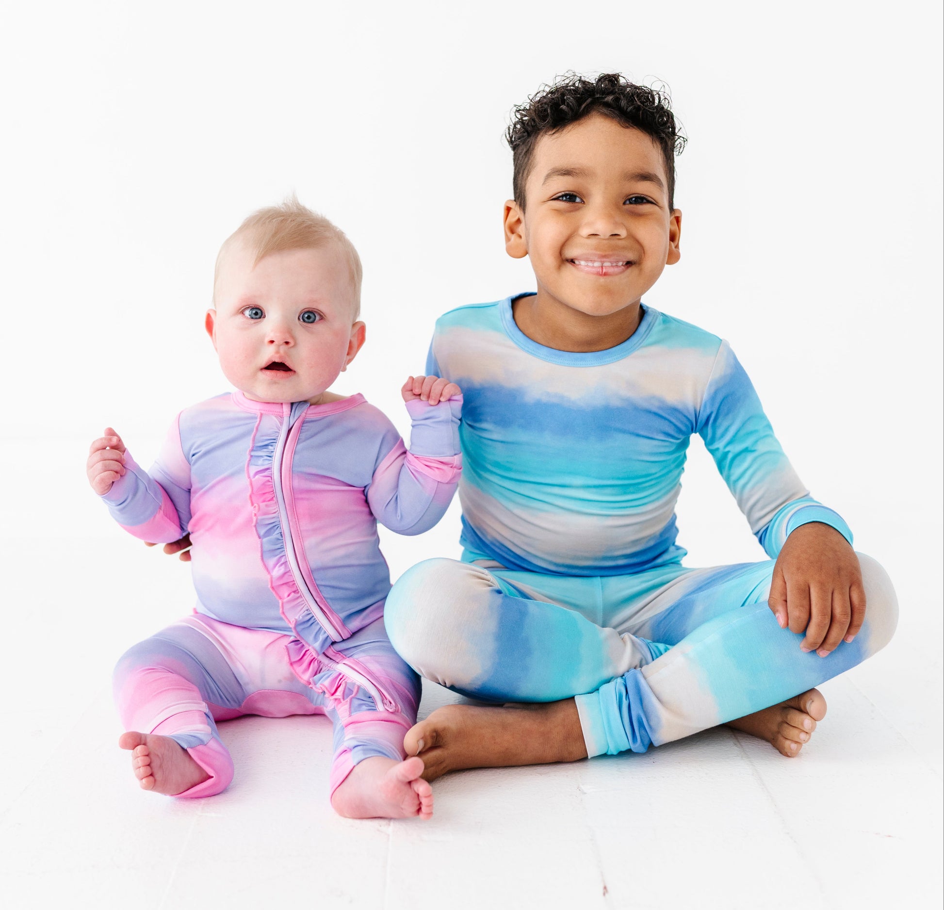 Two children wearing colorful striped bamboo sleepwear on a white background