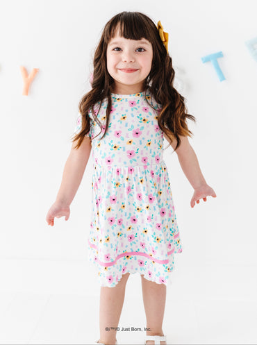 Young girl wearing a floral PEEPS® dress on a white background