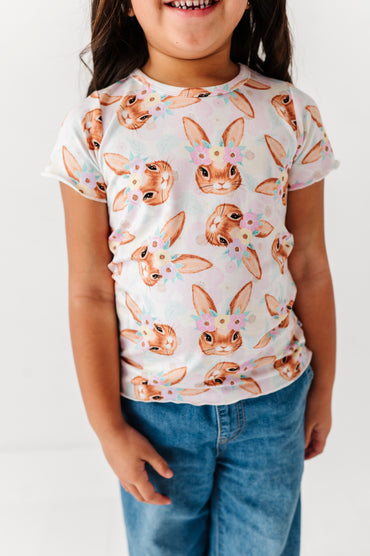 Child wearing a t-shirt with bunny print against a white background