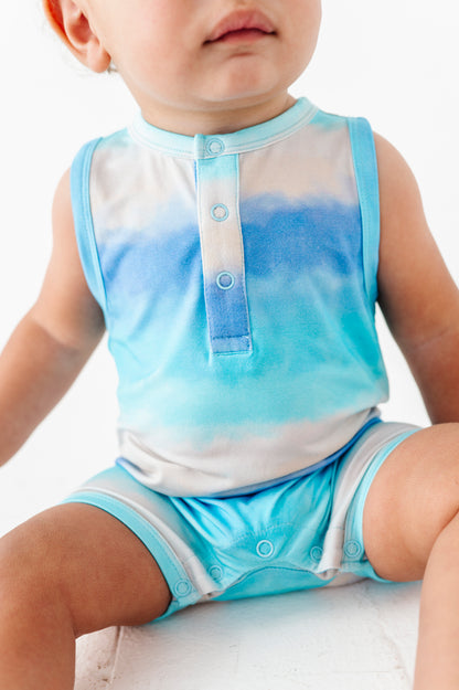 Baby wearing a blue and white sleeveless shirt and shorts set on a white background